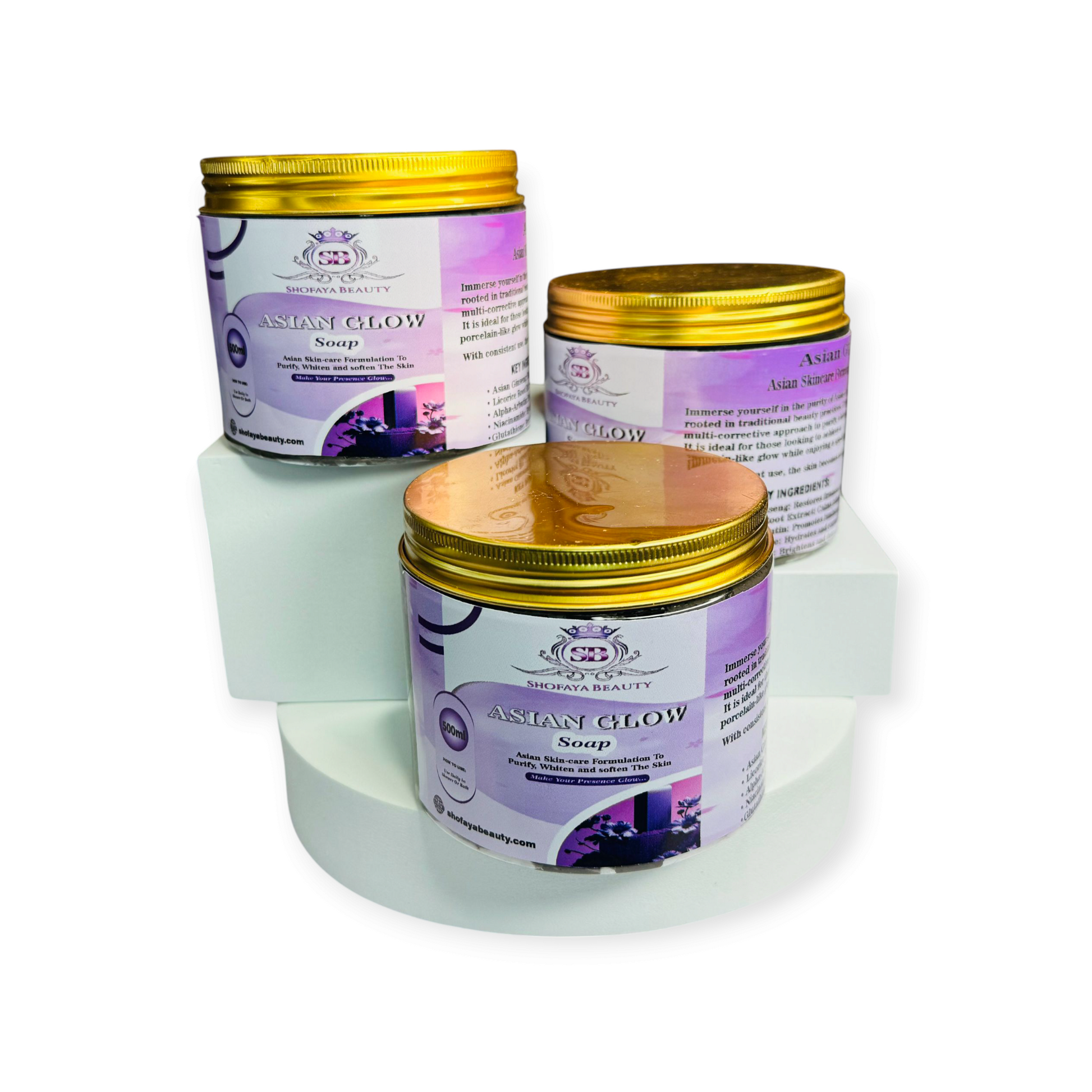 Three Asian Glow soap containers with gold lids on a white background